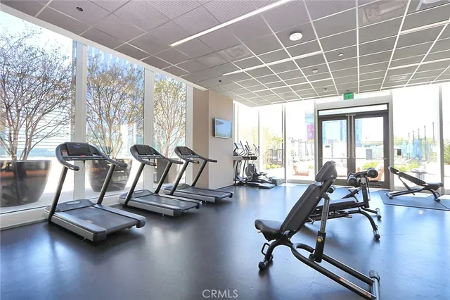 a view of a room with lots of furniture and large windows