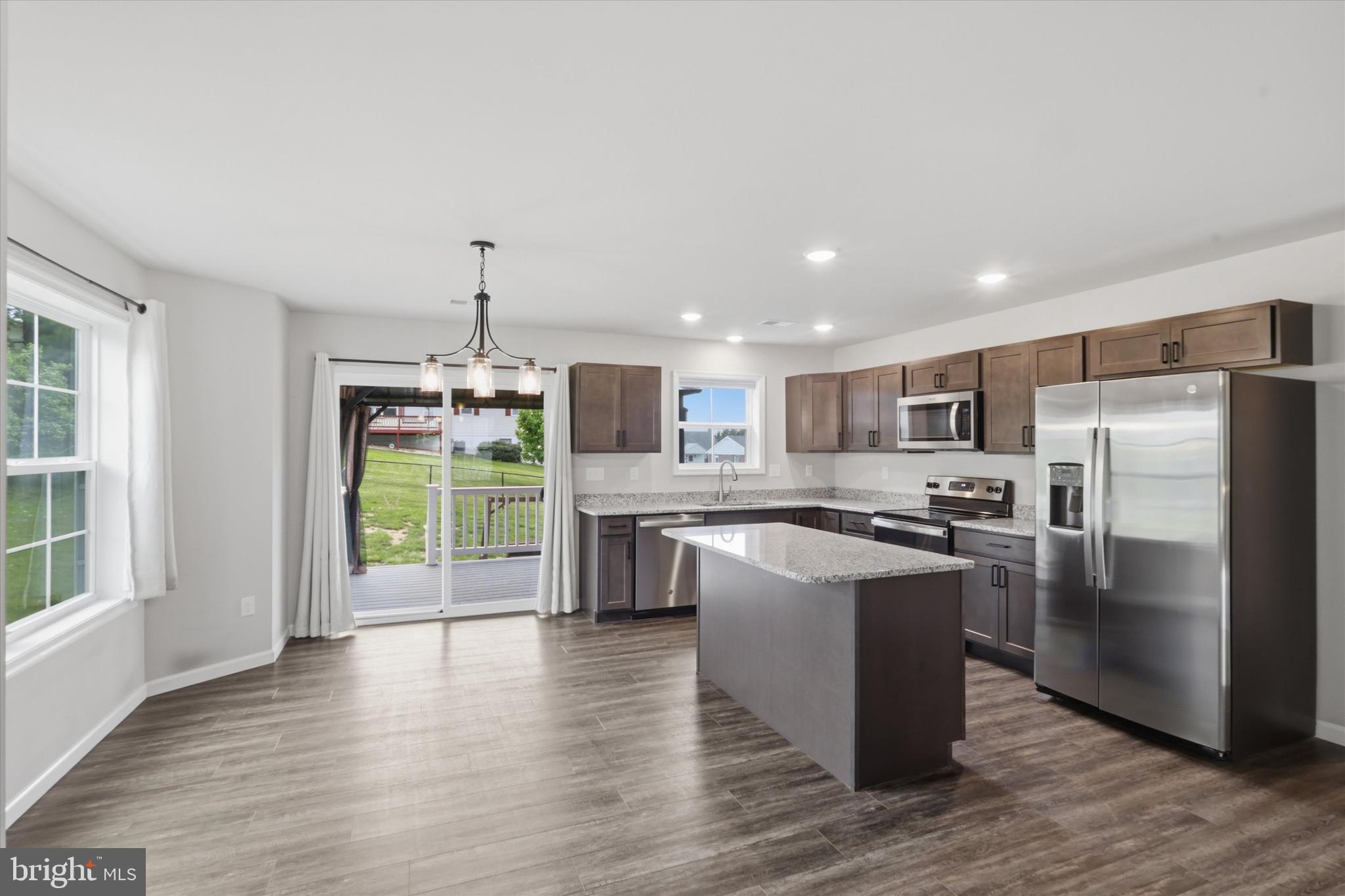 338 Grandview Avenue Waynesboro, PA 17268 - Photo 6 of 40 a kitchen with stainless steel appliances granite countertop a stove top oven a sink dishwasher a refrigerator and a dining table with wooden floor