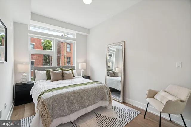 a bedroom with a bed wooden floor and a rug