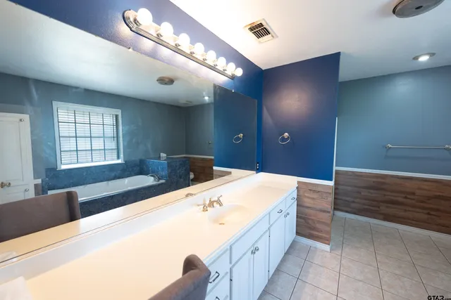 a bathroom with a tub a sink and a window