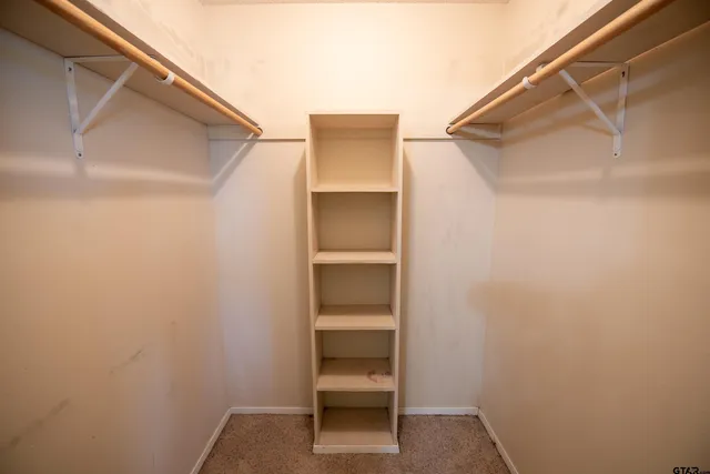 a view of an empty room with window and fan