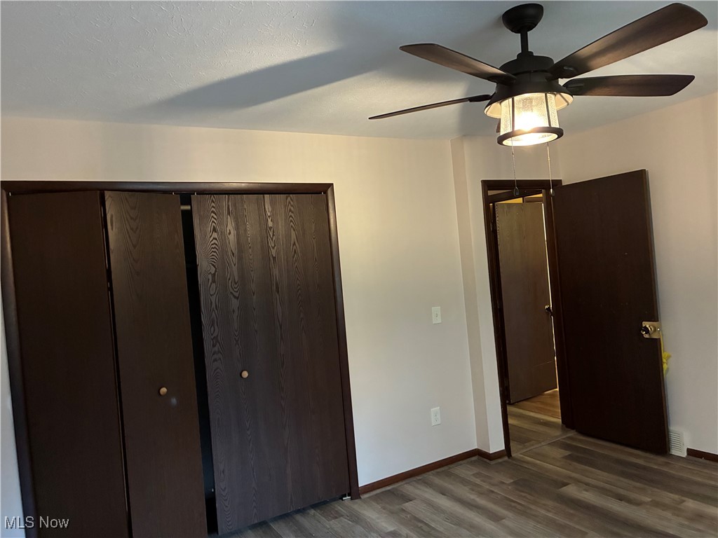 3351-3353 Mayfield Road Cleveland, OH 44118 - Photo 9 of 13 Unfurnished bedroom with a closet, dark wood-style floors, and a ceiling fan