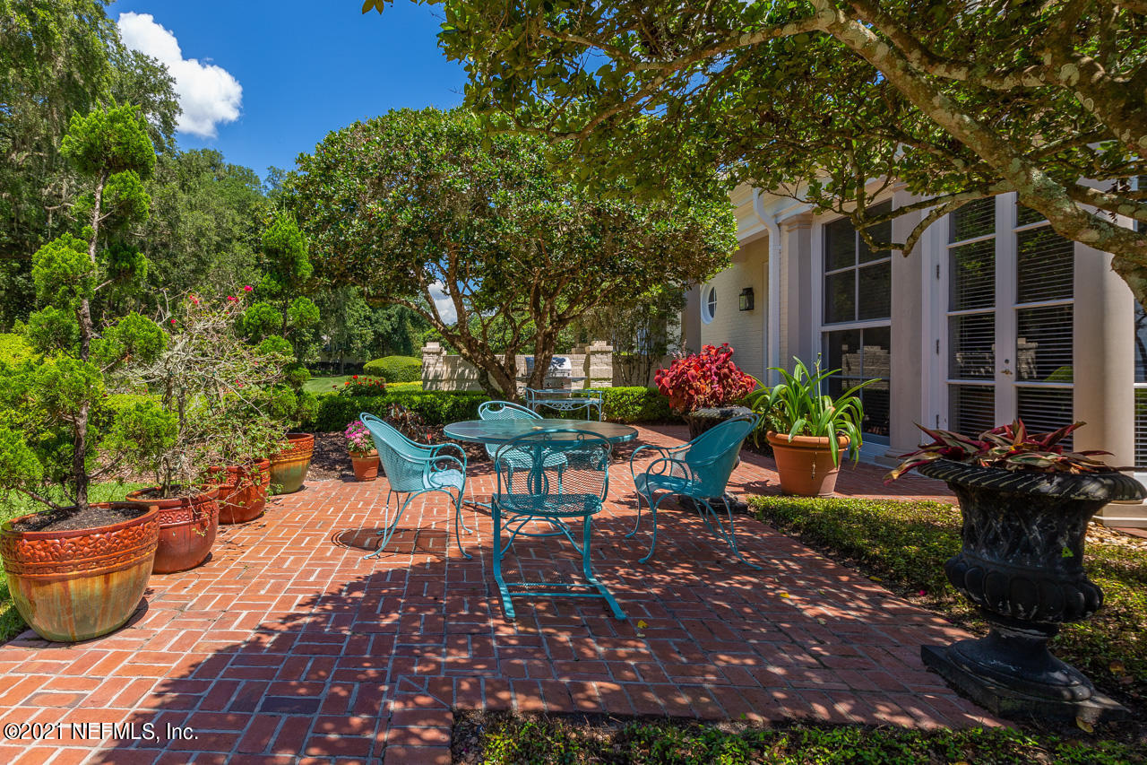 2180 Eventide Avenue St. Johns, FL 32259 - Photo 18 of 91 a view of a patio with table and chairs potted plants and large tree