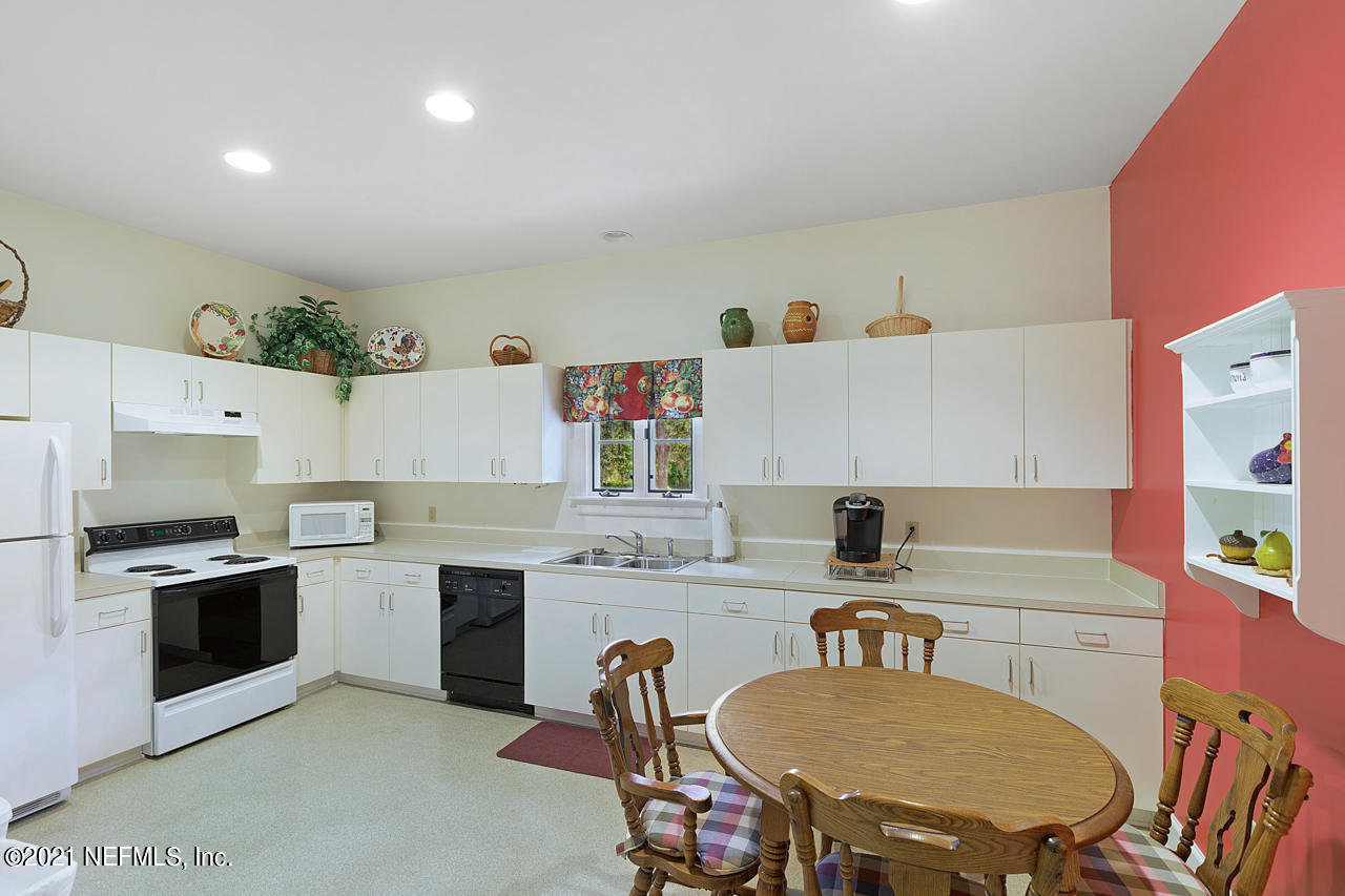 2180 Eventide Avenue St. Johns, FL 32259 - Photo 53 of 91 a kitchen with stainless steel appliances a stove a sink a microwave a dining table and chairs