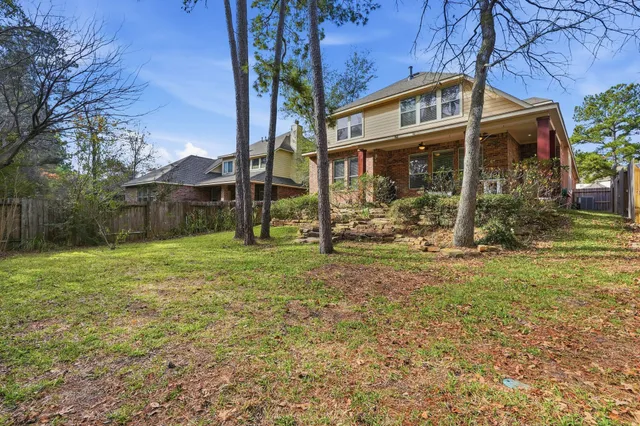 a view of a house with backyard and a tree