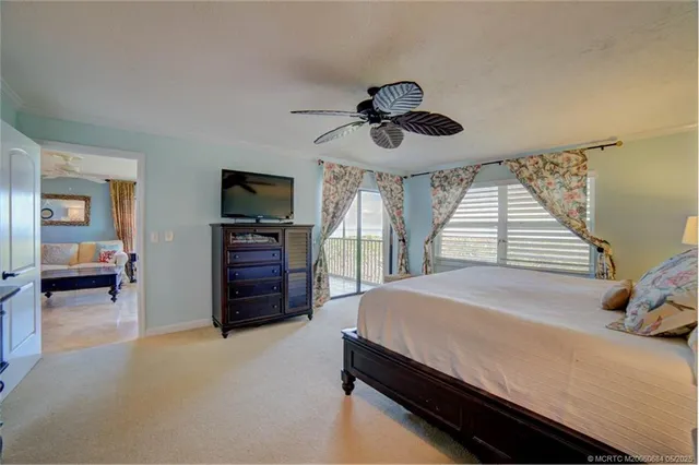 a bedroom with a bed and a flat tv screen on dresser