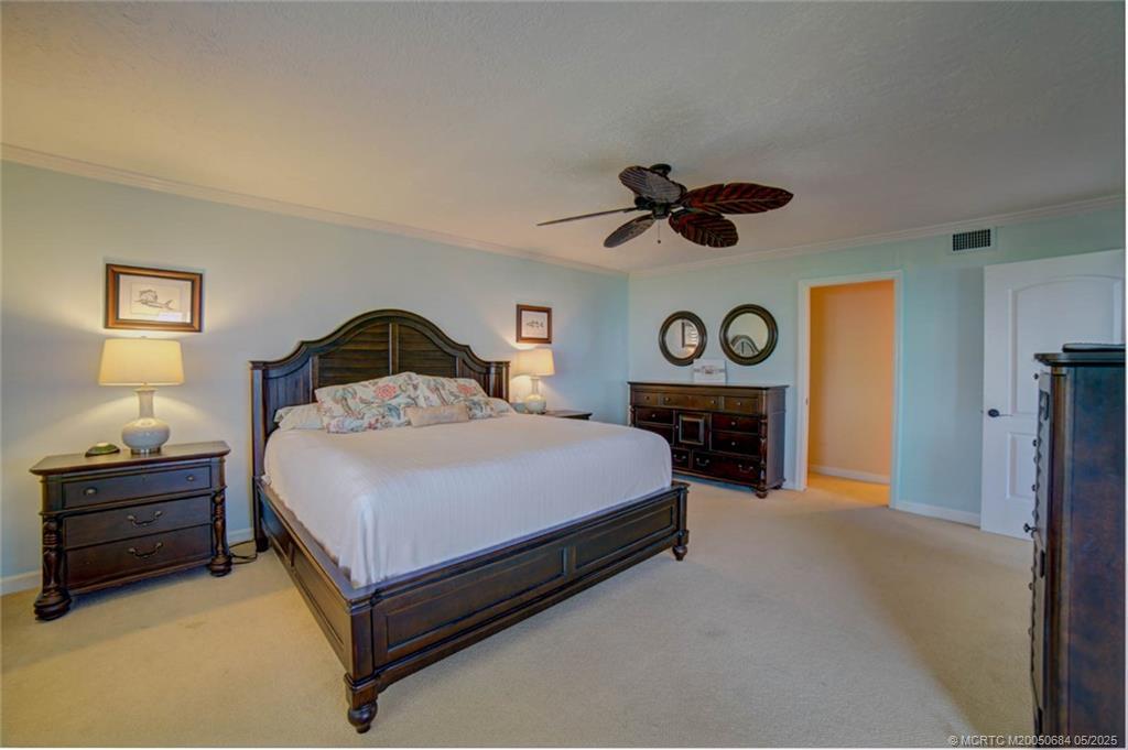 2491 Northeast Ocean Boulevard, Unit 103 Stuart, FL 34996 - Photo 22 of 38 a bedroom with a bed and a chandelier