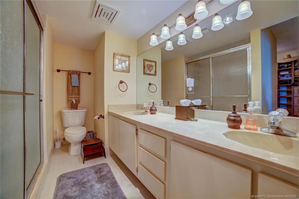 2491 Northeast Ocean Boulevard, Unit 103 Stuart, FL 34996 - Photo 23 of 38 a spacious bathroom with a double vanity sink mirror and toilet