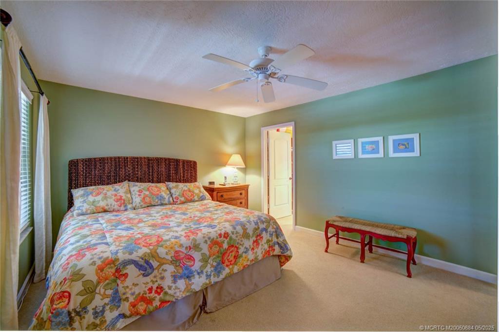 2491 Northeast Ocean Boulevard, Unit 103 Stuart, FL 34996 - Photo 25 of 38 a bedroom with a bed and a chandelier