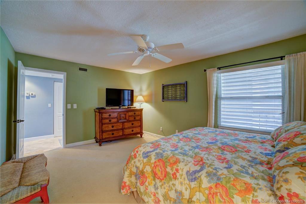 2491 Northeast Ocean Boulevard, Unit 103 Stuart, FL 34996 - Photo 26 of 38 a bedroom with a bed and a flat screen tv