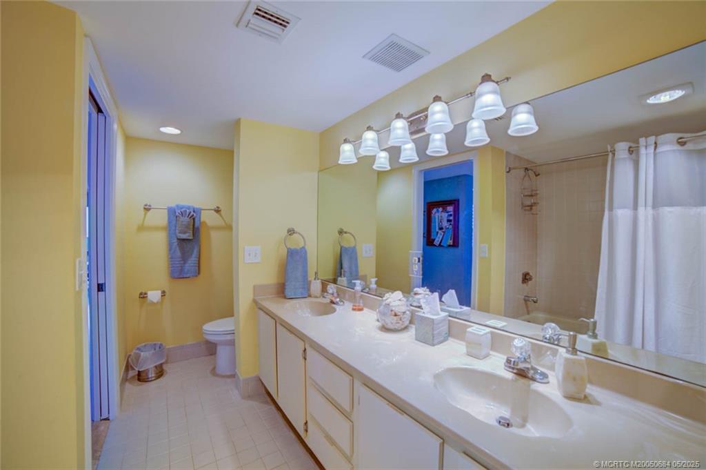 2491 Northeast Ocean Boulevard, Unit 103 Stuart, FL 34996 - Photo 27 of 38 a spacious bathroom with a sink double vanity and a mirror