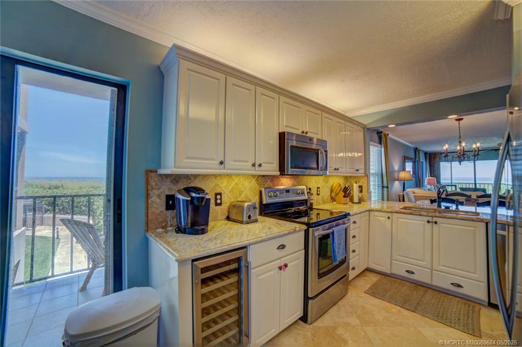 2491 Northeast Ocean Boulevard, Unit 103 Stuart, FL 34996 - Photo 28 of 38 a kitchen with stainless steel appliances granite countertop a stove top oven a sink a counter space and cabinets