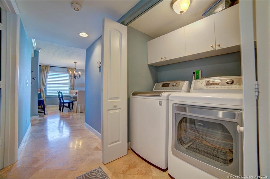 2491 Northeast Ocean Boulevard, Unit 103 Stuart, FL 34996 - Photo 29 of 38 a view of washer and dryer with kitchen in the background