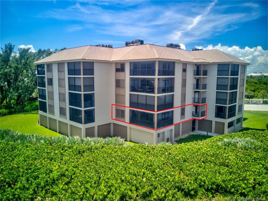 2491 Northeast Ocean Boulevard, Unit 103 Stuart, FL 34996 - Photo 6 of 38 a view of a large building with a big yard and plants