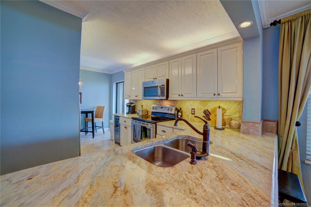 2491 Northeast Ocean Boulevard, Unit 103 Stuart, FL 34996 - Photo 8 of 38 a view of a kitchen with dining area a sink and wooden floor