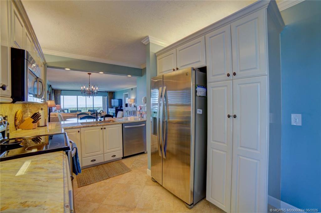 2491 Northeast Ocean Boulevard, Unit 103 Stuart, FL 34996 - Photo 9 of 38 a kitchen with a refrigerator and a stove