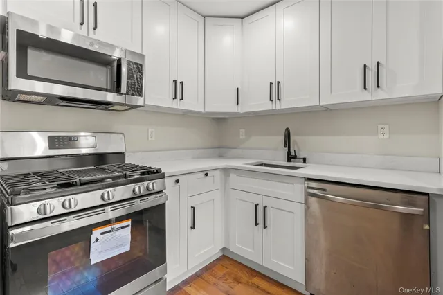 a kitchen with white cabinets and stainless steel appliances