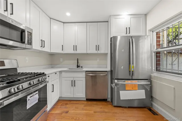 a kitchen with stainless steel appliances granite countertop a refrigerator a stove and a sink
