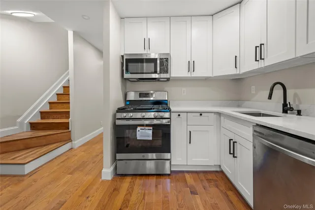a kitchen with stainless steel appliances a stove microwave and sink