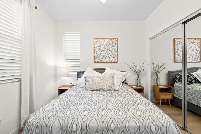 a bedroom with a bed a lamp and a large window