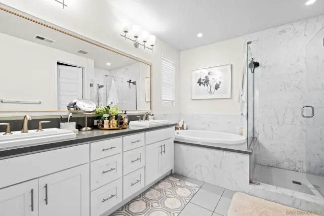 a bathroom with a double vanity sink a toilet a mirror and shower