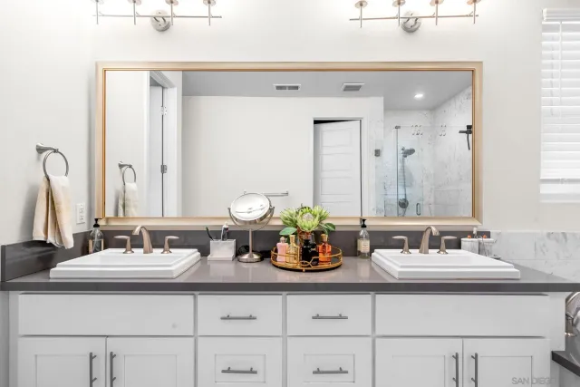 a bathroom with double sink and a mirror
