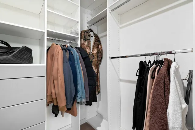 a view of walk in closet with clothes and shoes