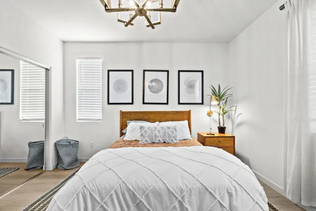 a bedroom with a large bed and a chandelier