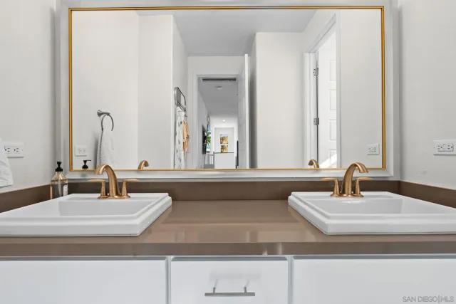 a bathroom with double vanity sinks and a mirror