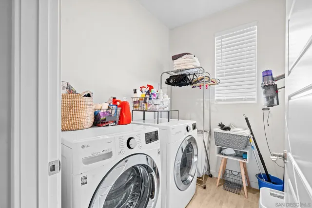 a utility room with dryer washer and a view of living room
