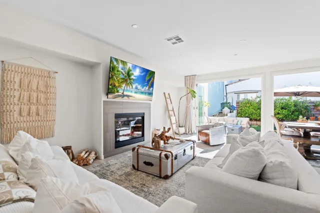 a living room with fireplace furniture and a large window