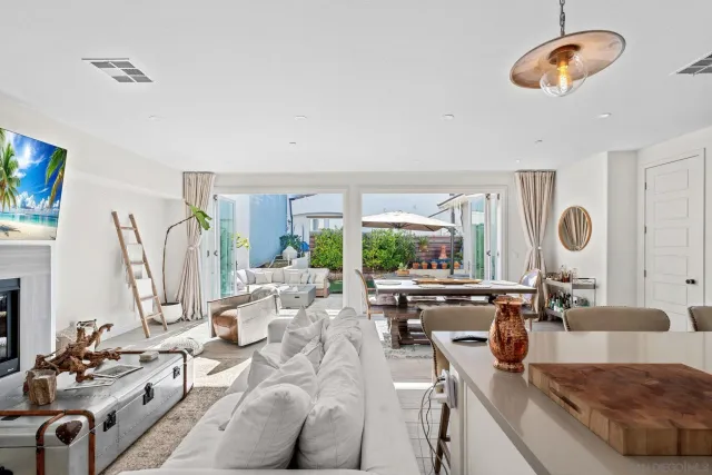 a living room with furniture kitchen view and large windows