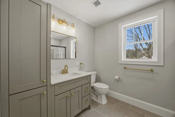 a bathroom with a toilet sink and mirror