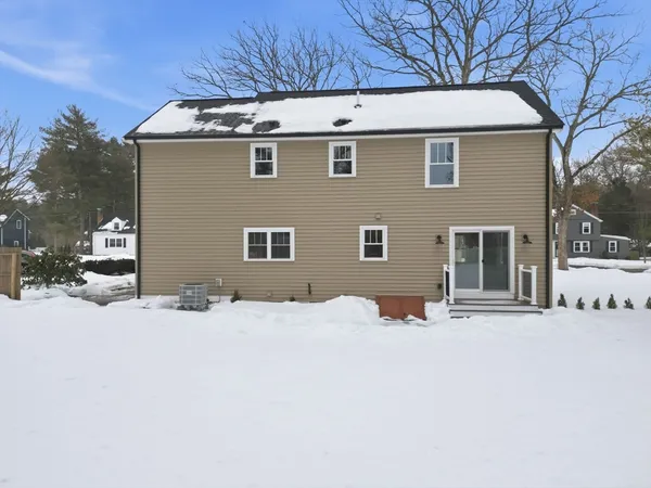 a front view of a house with a yard covered in snow