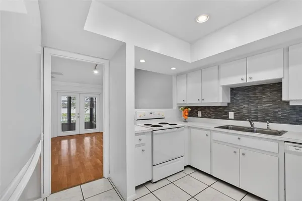 a kitchen with white cabinets and refrigerator