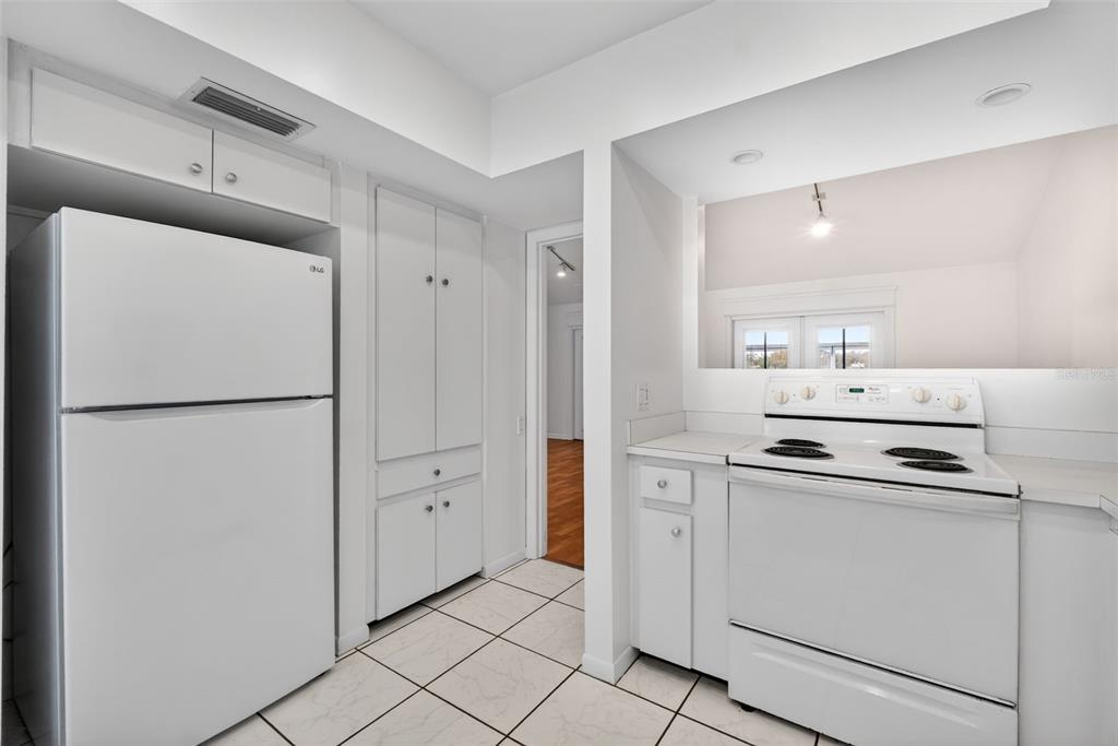 1502 Buckeye Road Northeast, Unit 4 Winter Haven, FL 33881 - Photo 12 of 49 a kitchen with white cabinets and refrigerator