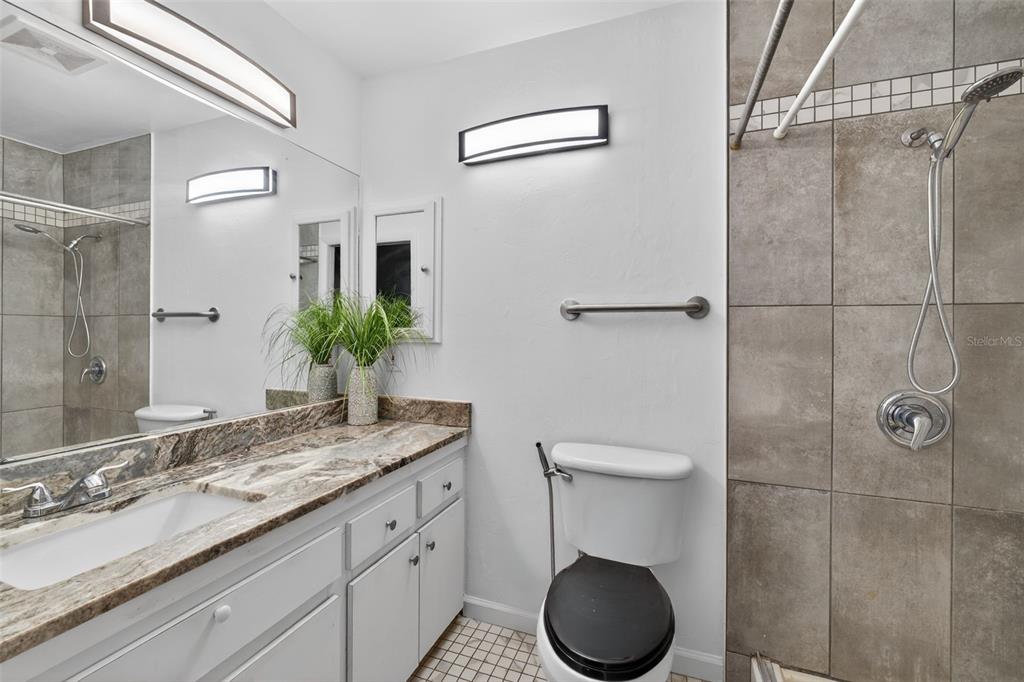 1502 Buckeye Road Northeast, Unit 4 Winter Haven, FL 33881 - Photo 23 of 49 a bathroom with a granite countertop sink toilet and a mirror