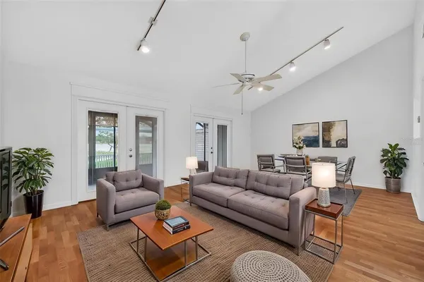 a view of an empty room with a window and chandelier fan