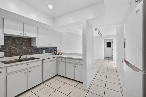 a kitchen with white cabinets appliances and a sink