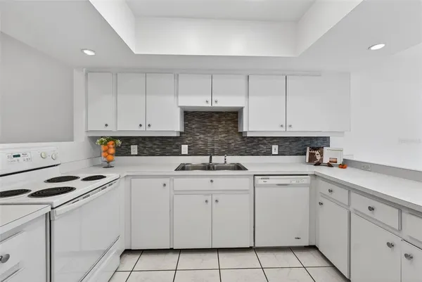 a kitchen with white cabinets appliances and a sink