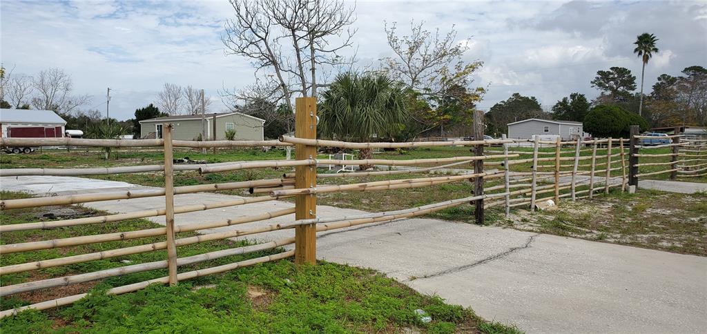 a view of a yard with wooden fence