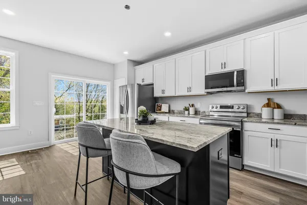 a kitchen with a stove a sink a microwave and cabinets