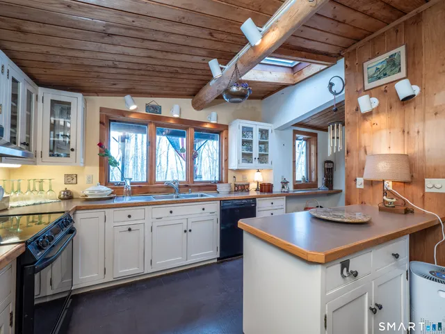 a kitchen with stainless steel appliances granite countertop a sink a stove and cabinets