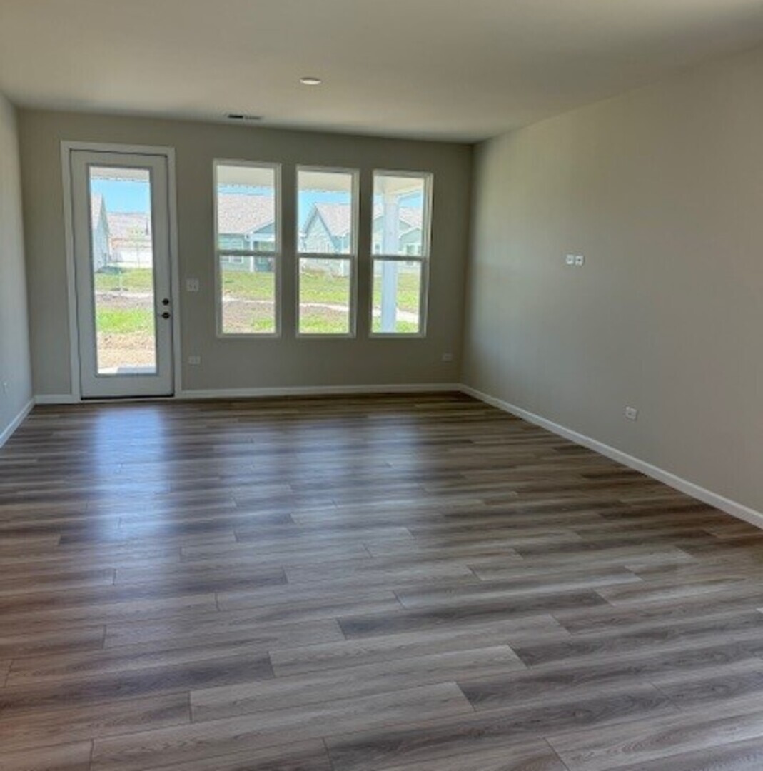 3302 Wildlight Road Aurora, IL 60503 - Photo 5 of 11 a view of an empty room with wooden floor and window