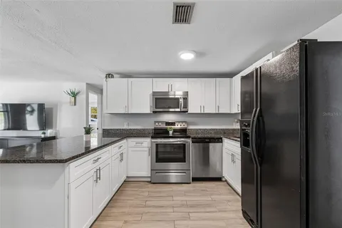 a kitchen with stainless steel appliances granite countertop a stove a refrigerator and a sink