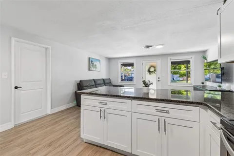 a kitchen with white cabinets and sink
