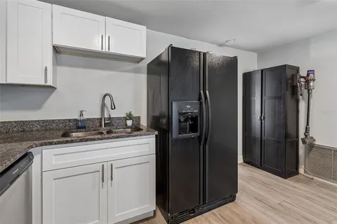 a kitchen with stainless steel appliances granite countertop a refrigerator and a sink