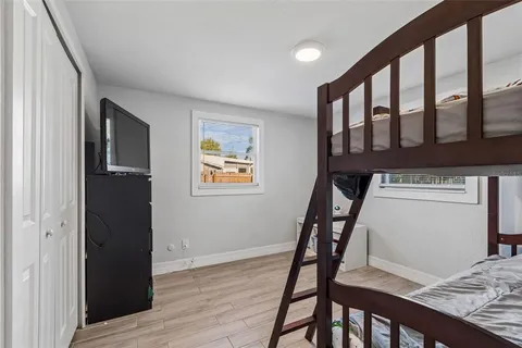 a bedroom with a bed and wooden floor