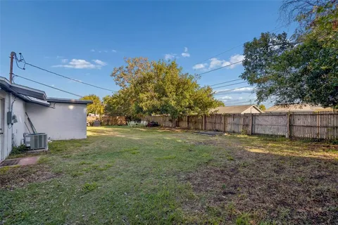a view of a house with backyard and trees