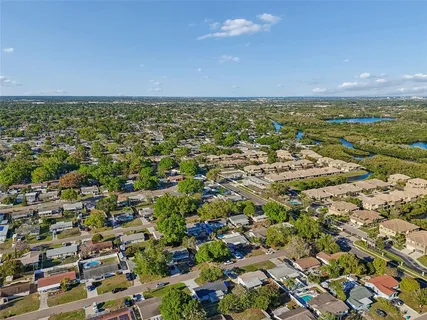 an aerial view of residential houses with outdoor space and trees